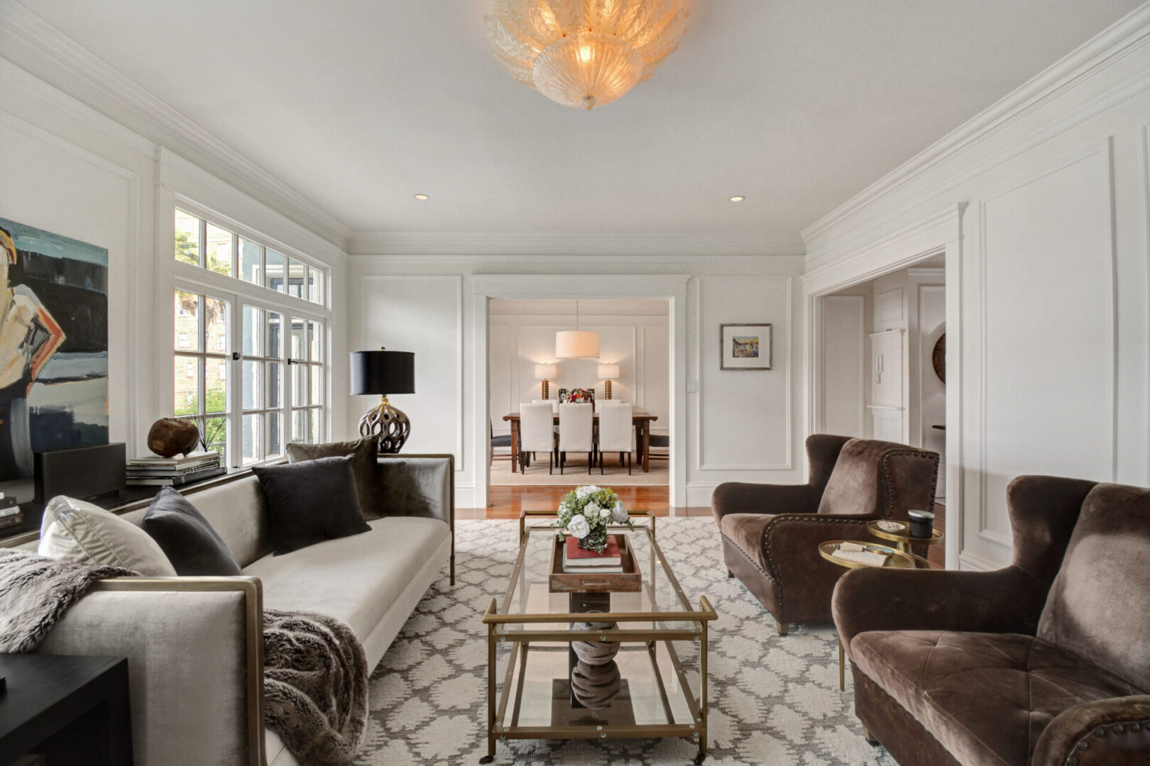 A living room with couches, chairs and tables.